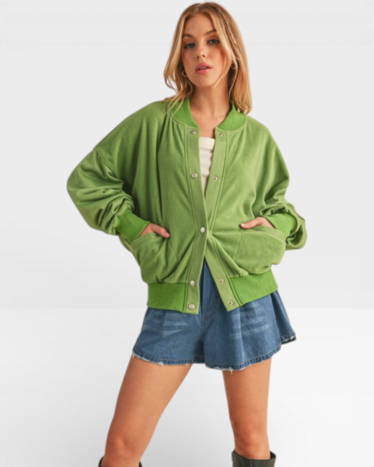 Woman wearing a green jacket and denim skirt on a white background