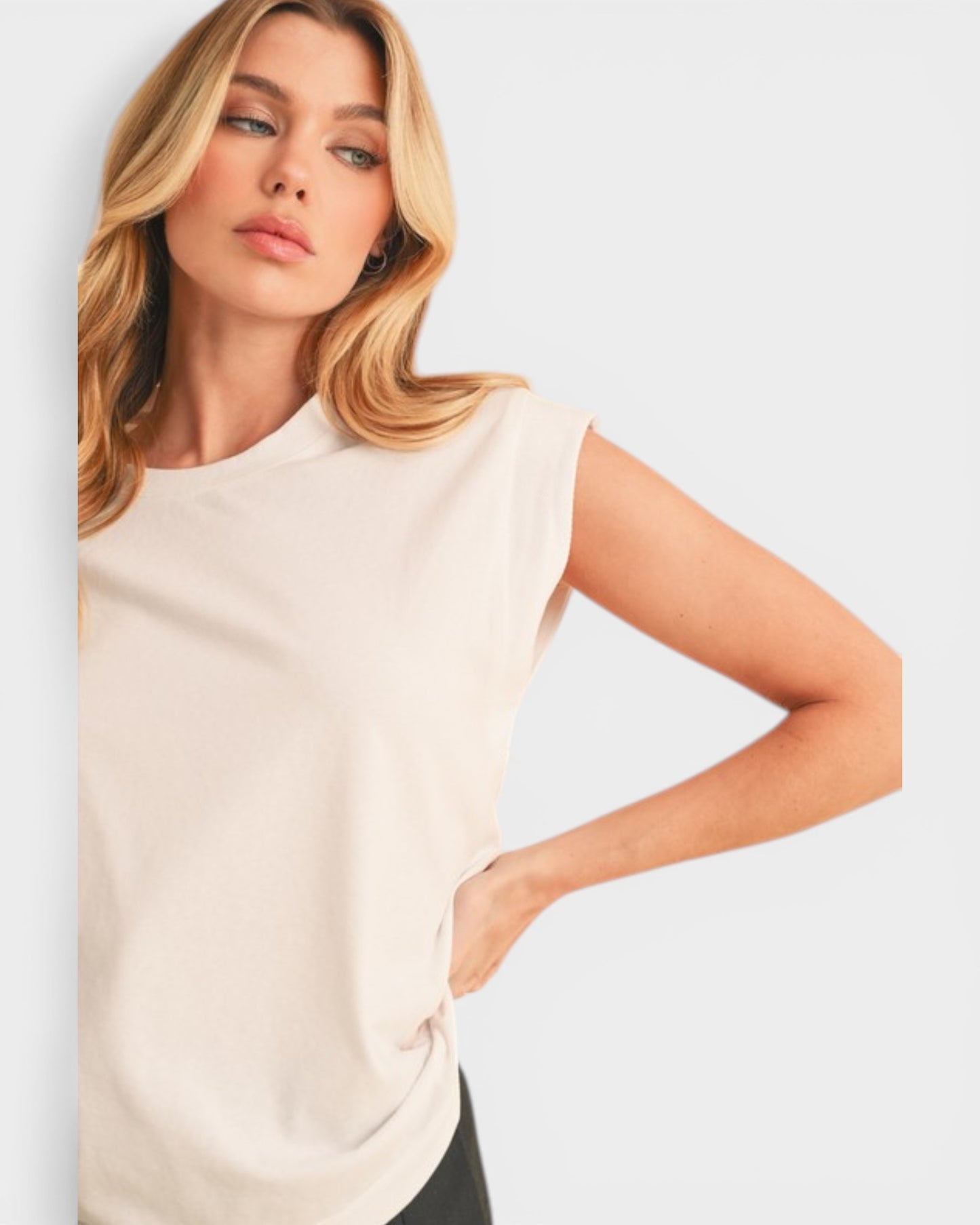 Woman wearing a beige sleeveless top on a light gray background
