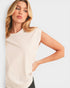 Woman wearing a beige sleeveless top on a light gray background