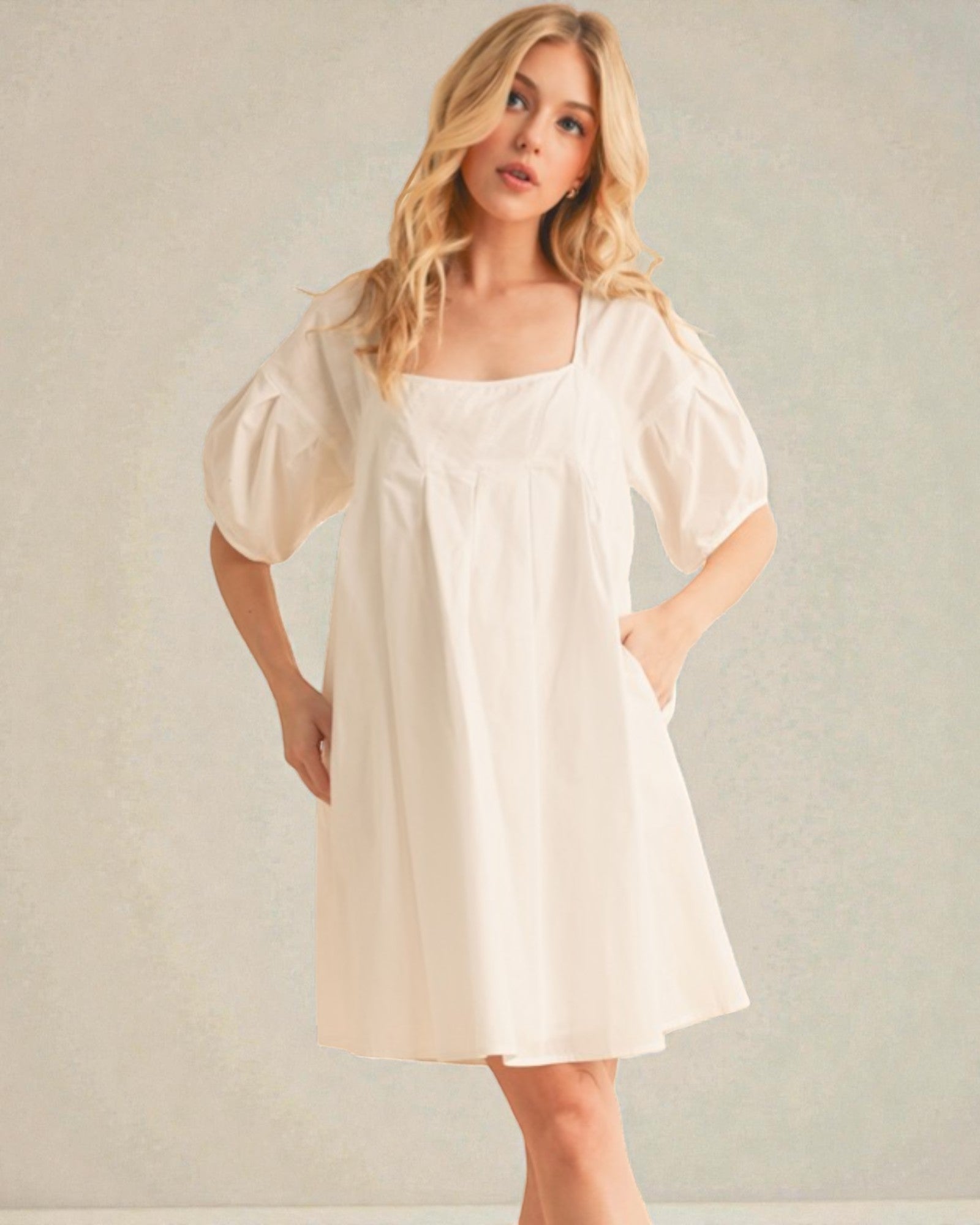 Woman wearing a white dress against a plain background