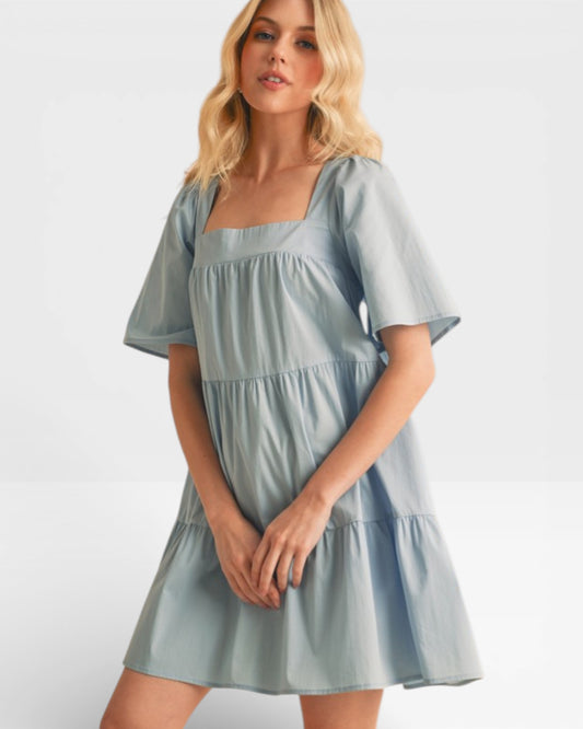 Woman wearing a light blue dress on a white background