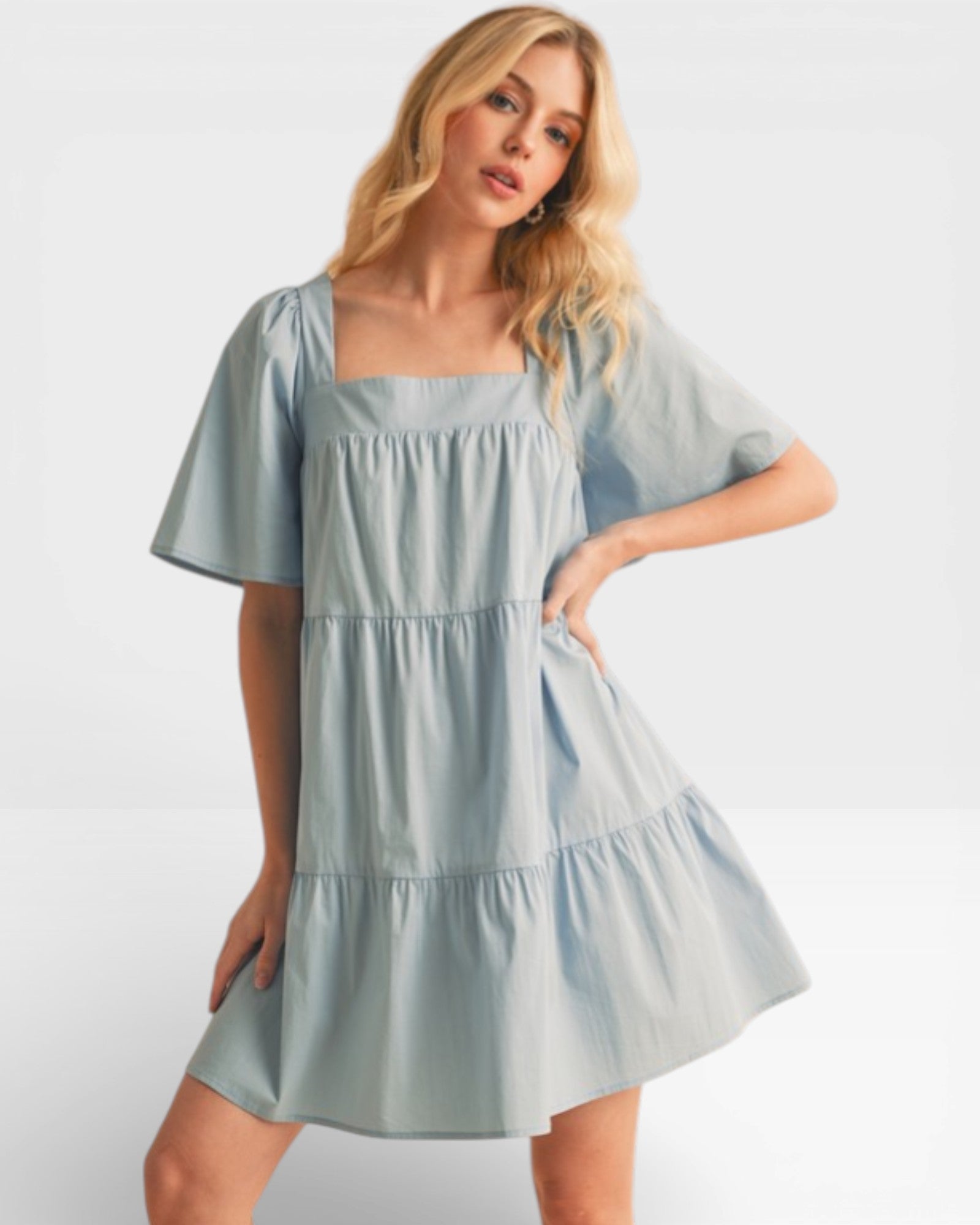 Woman wearing a light blue dress against a white background