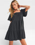 Woman wearing a black dress against a white background