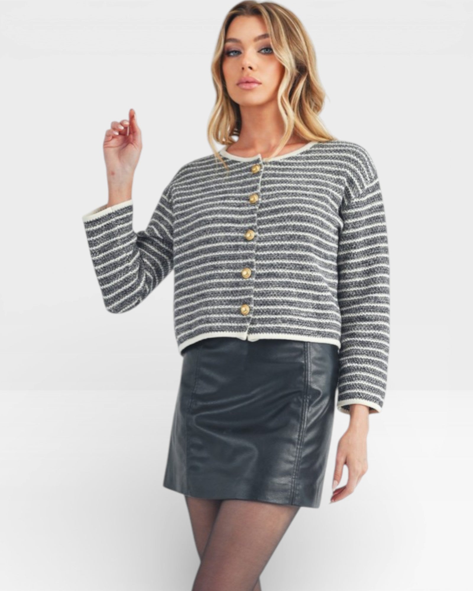 Woman wearing a striped sweater and leather skirt on a white background