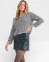 Woman wearing a striped sweater and black leather skirt on a white background