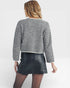 Person wearing a striped sweater and black leather skirt on a white background