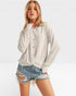 Woman wearing a light gray button-up shirt and denim shorts on a white background