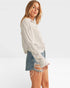 Woman wearing a white blouse and denim shorts on a plain background
