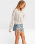 Woman wearing a white button-up shirt and denim shorts on a white background
