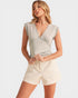 Woman wearing a beige romper on a white background
