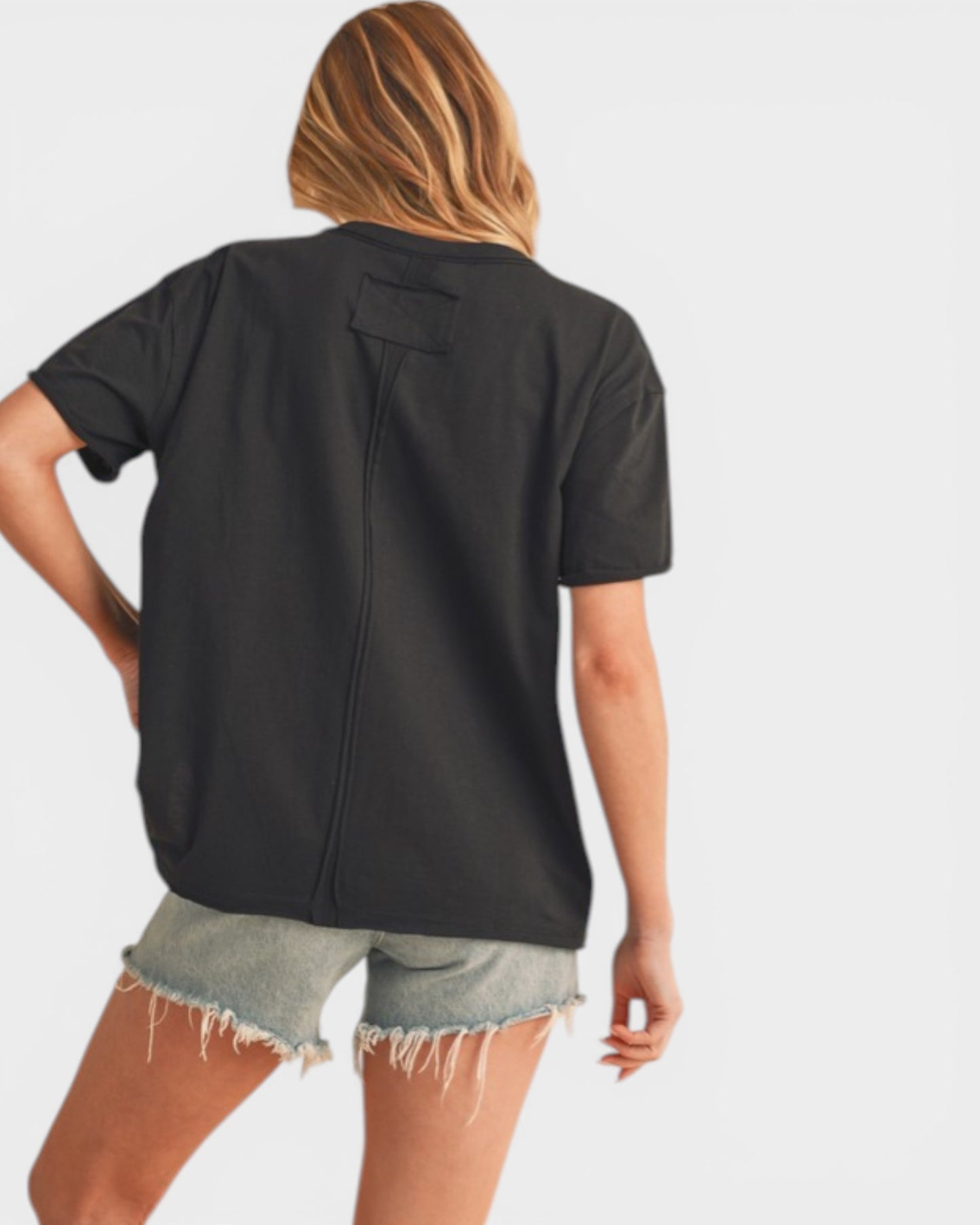 Person wearing a black t-shirt and denim shorts on a white background