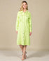 Woman wearing a light green dress against a beige background
