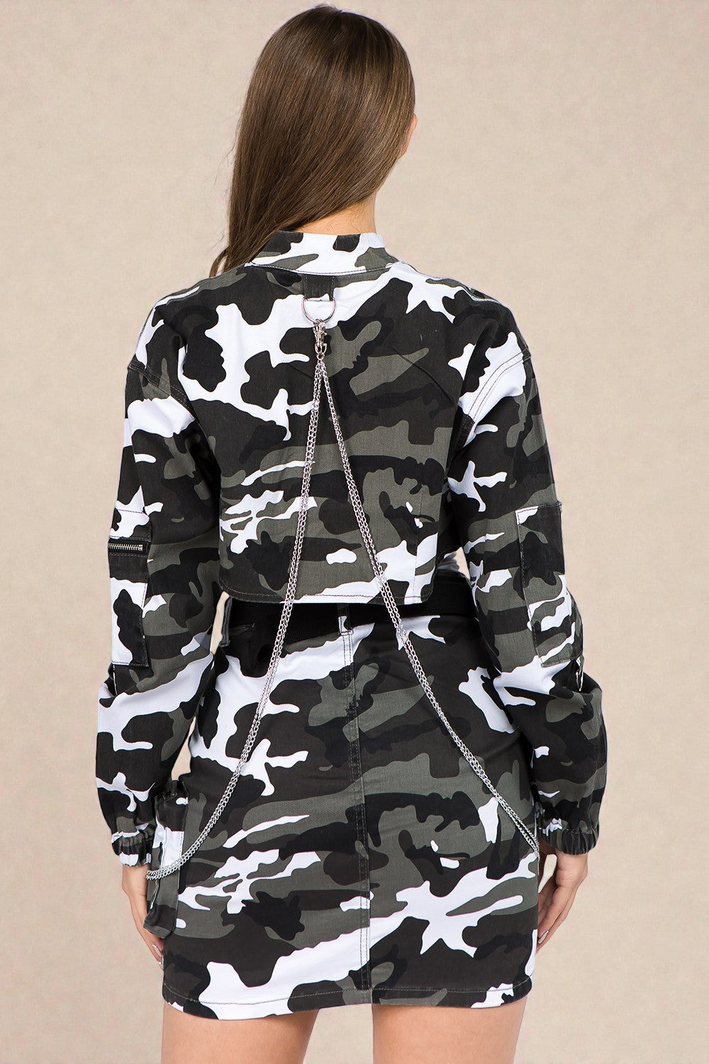 Person wearing a camouflage outfit with a neutral background