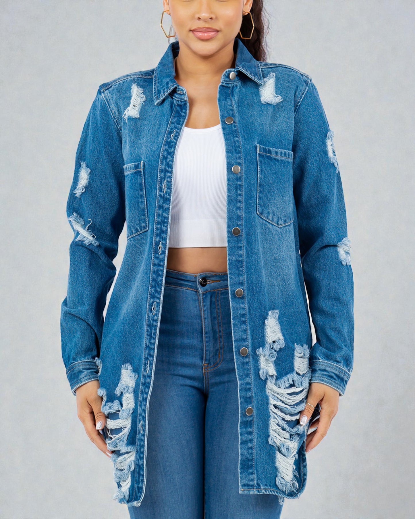Person wearing a distressed denim jacket and jeans on a gray background