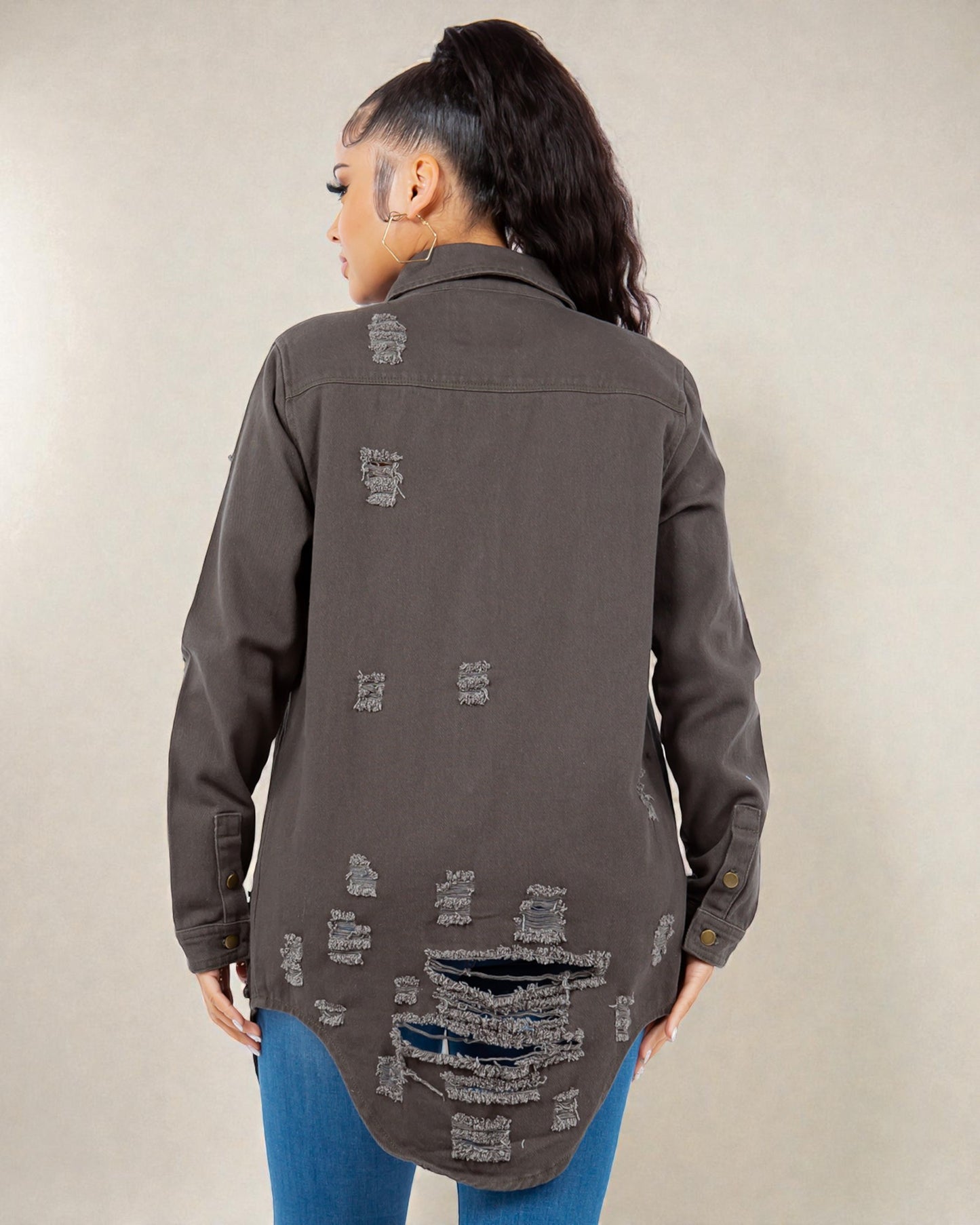 Person wearing a distressed gray jacket on a plain background