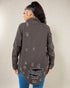 Person wearing a distressed gray jacket on a plain background