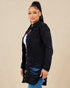 Woman wearing a black denim jacket on a beige background