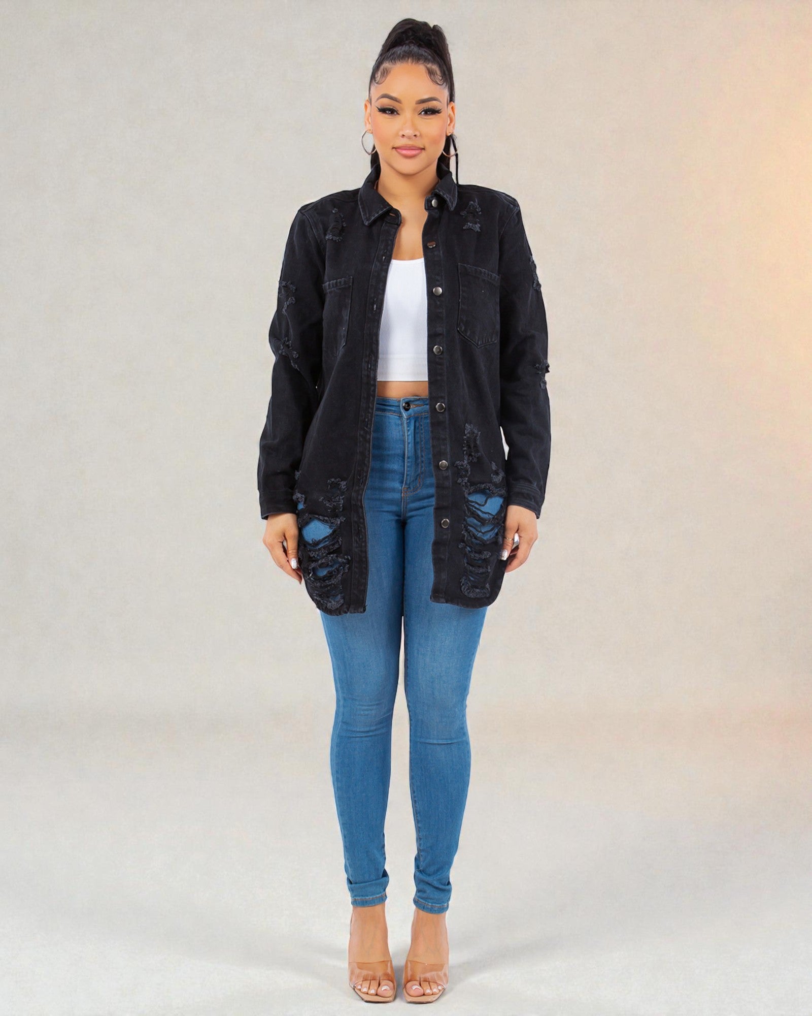 Woman wearing a black jacket and blue jeans on a gradient background