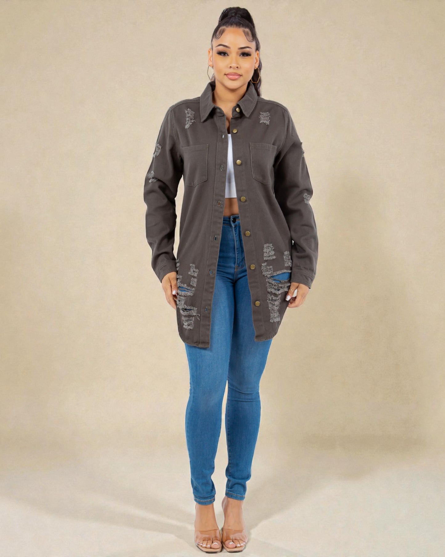 Woman wearing a gray jacket and blue jeans on a beige background
