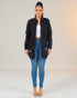 Woman wearing a black jacket and blue jeans on a gradient background