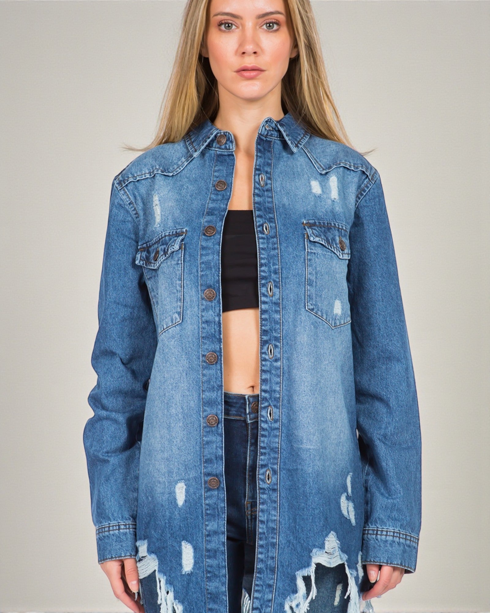 Woman wearing a blue denim jacket on a plain background