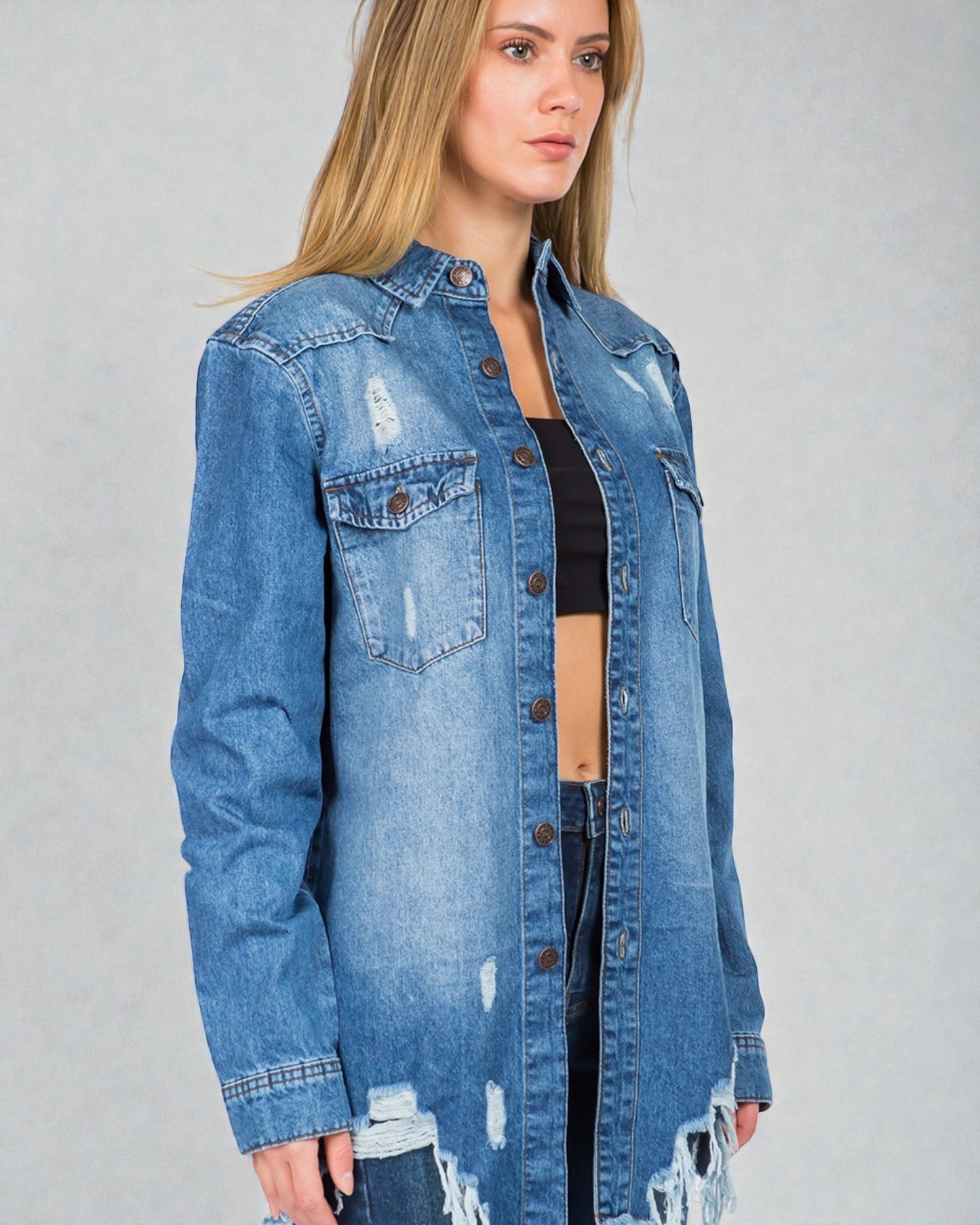 Woman wearing a blue denim jacket on a gray background