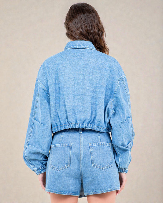 Person wearing a blue denim outfit on a beige background