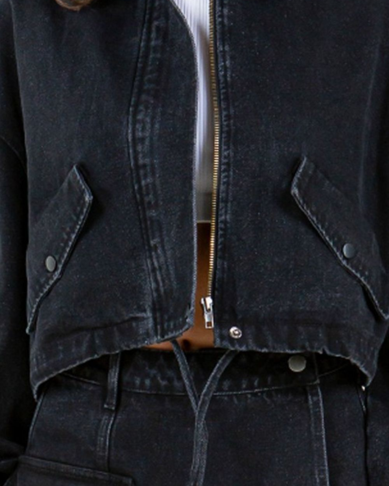 Close-up of a dark denim jacket with a zipper