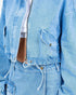 Close-up of a light blue denim jacket with a white shirt underneath.