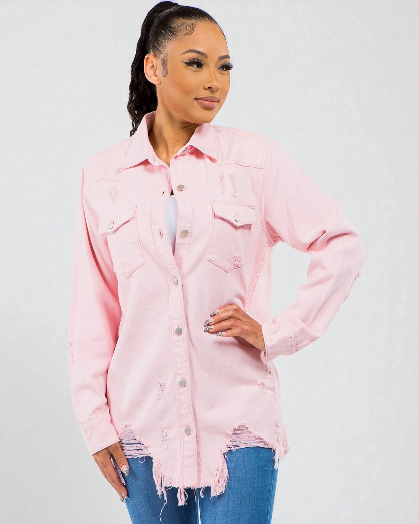 Woman wearing a pink denim jacket on a plain background