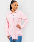 Woman wearing a pink denim jacket on a plain background