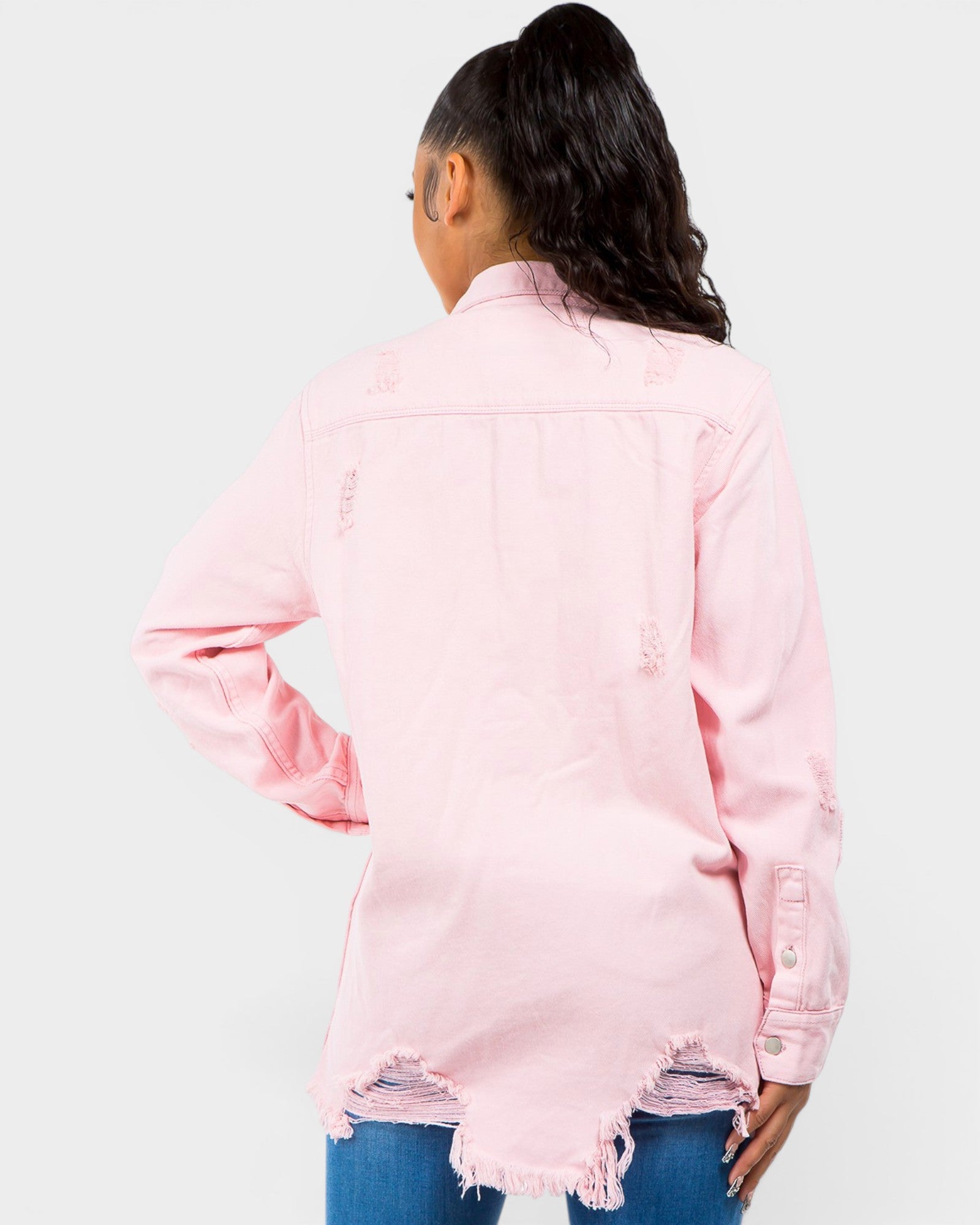 Person wearing a pink denim jacket with a white background