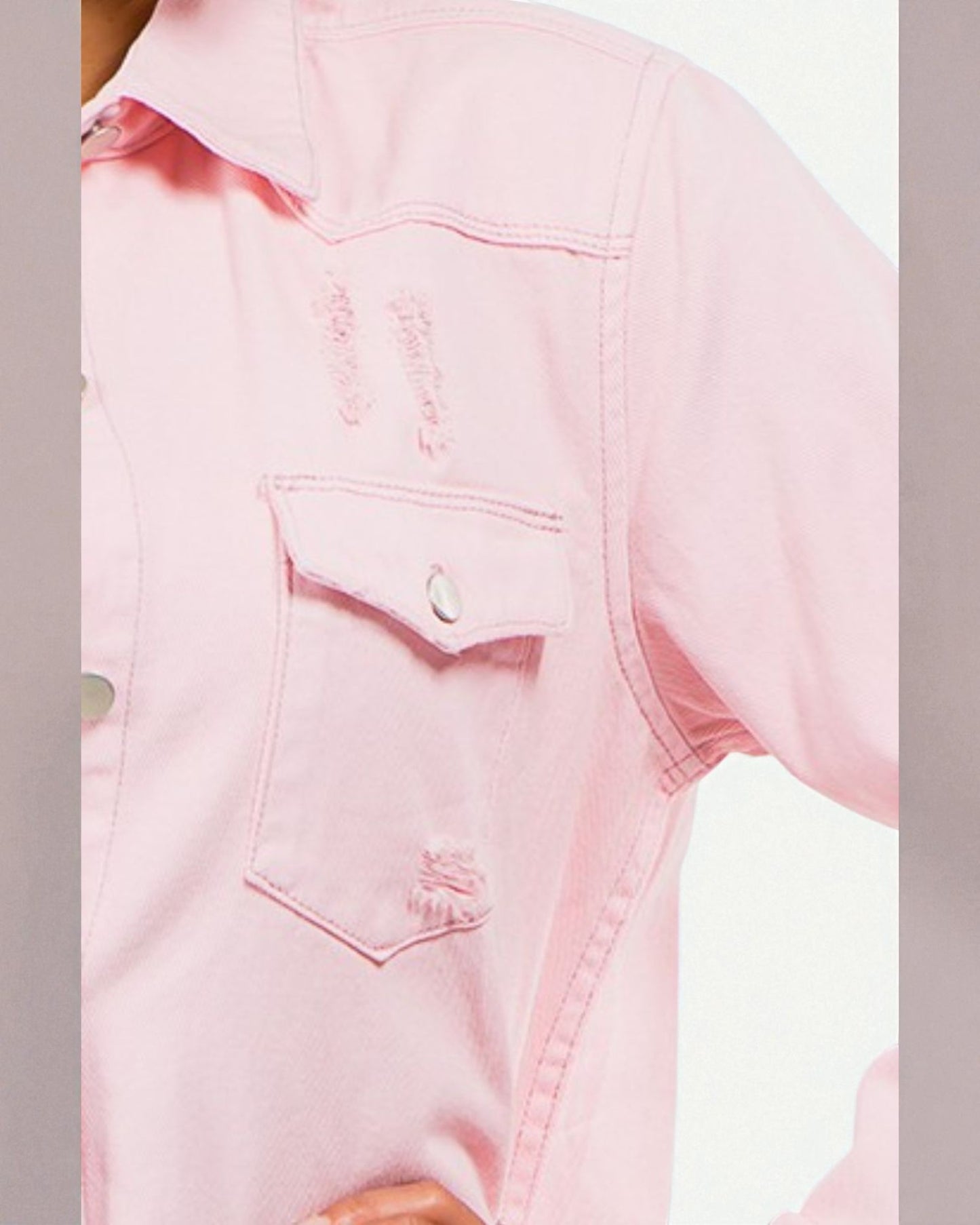 Close-up of a pink denim shirt with a pocket on a light gray background