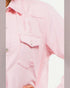 Close-up of a pink denim shirt with a pocket on a light gray background