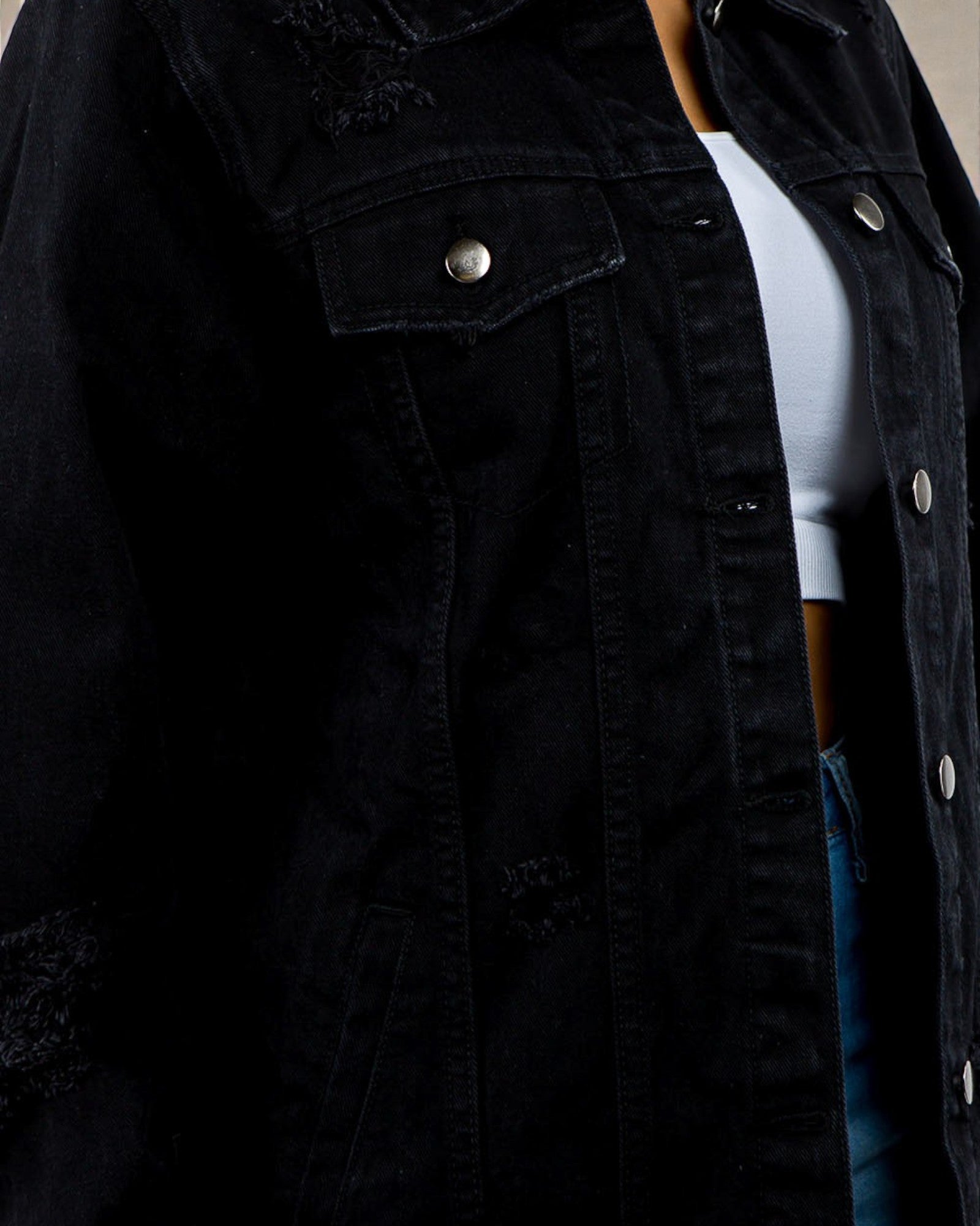 Black denim jacket with a person wearing it, partially visible