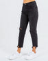 Black distressed jeans worn by a person on a white background