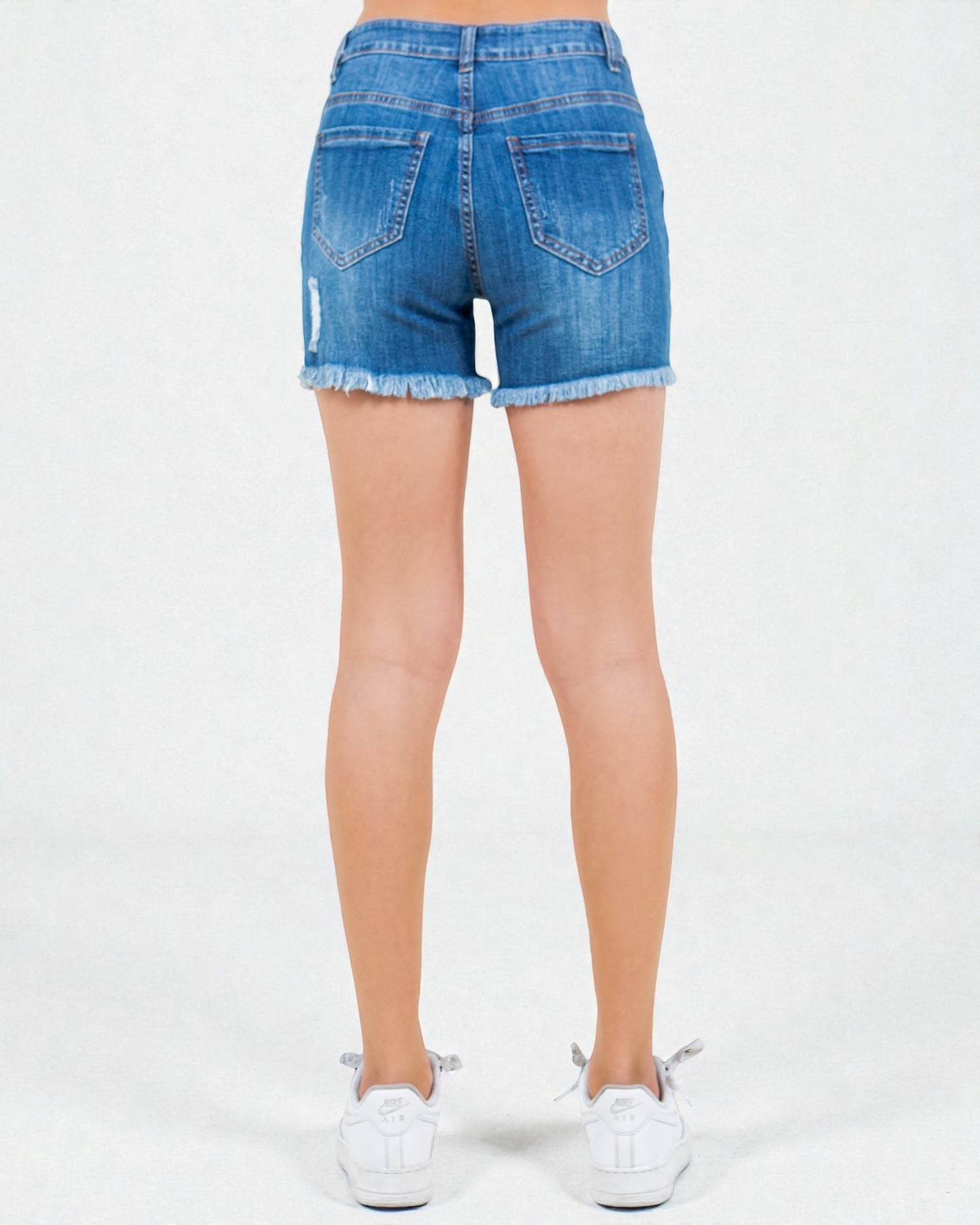Blue denim shorts worn by a person on a white background