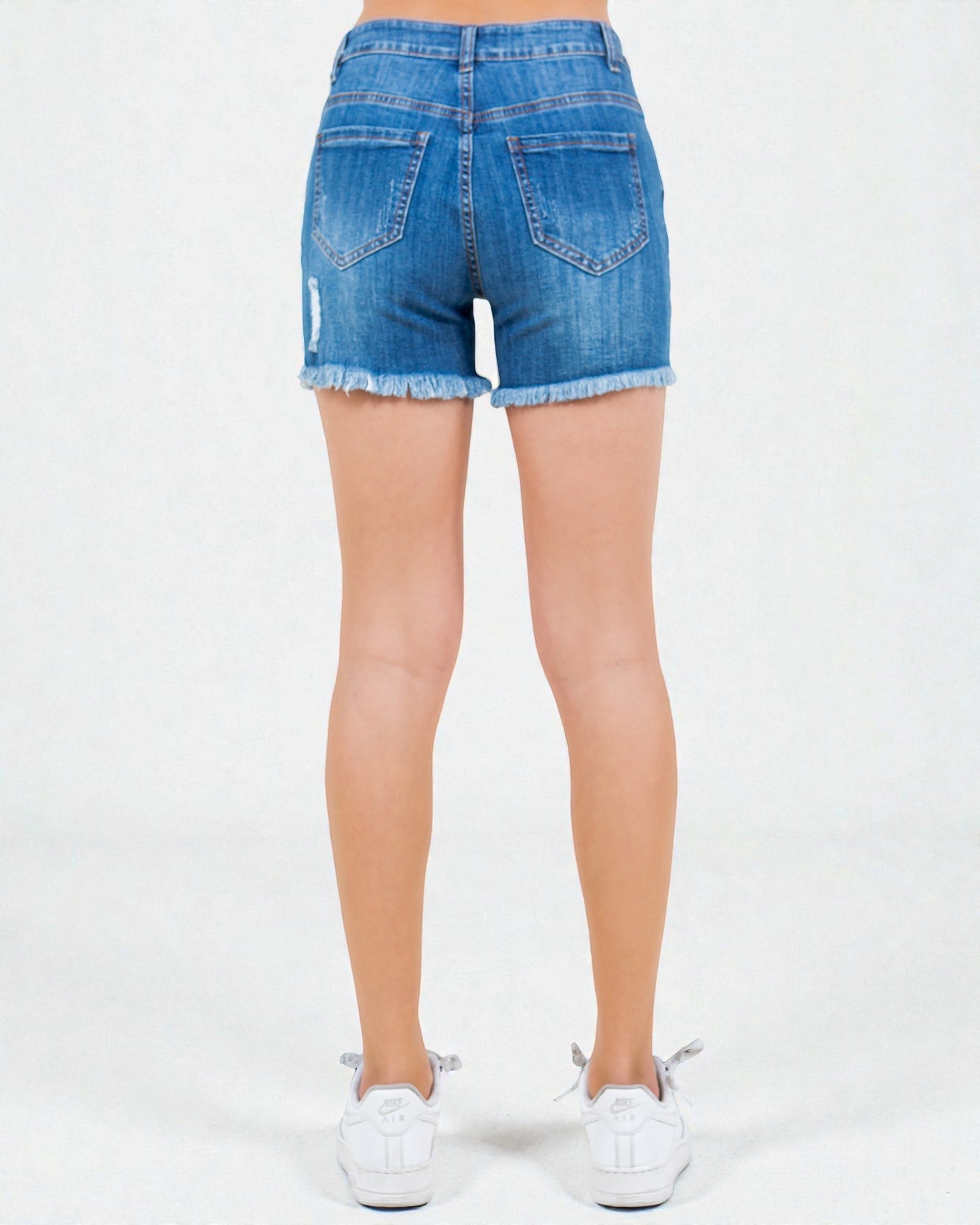 Blue denim shorts worn by a person on a white background