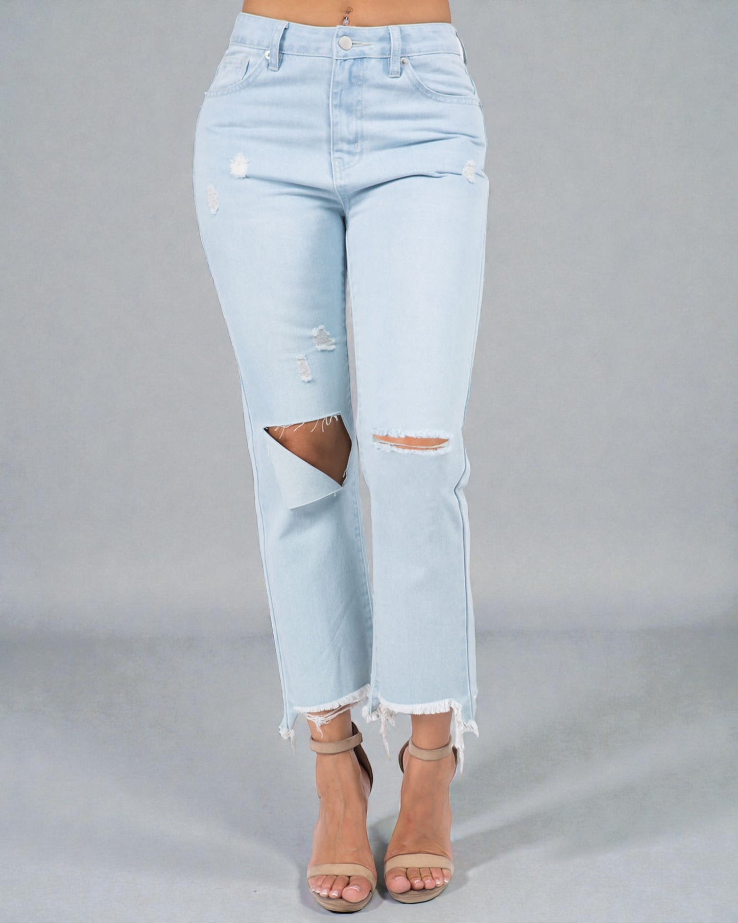 Light blue distressed jeans worn by a person on a gray background