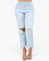 Light wash blue distressed jeans with ripped knee details and frayed hems, shown on a model wearing beige strappy high-heeled sandals against a plain white background.