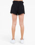 Black high-waisted shorts with a ruffled elastic waistband, shown on a model from the back against a plain white background.