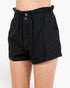 Black high-waisted shorts with a paperbag waistband and two front buttons, shown on a model against a plain white background.
