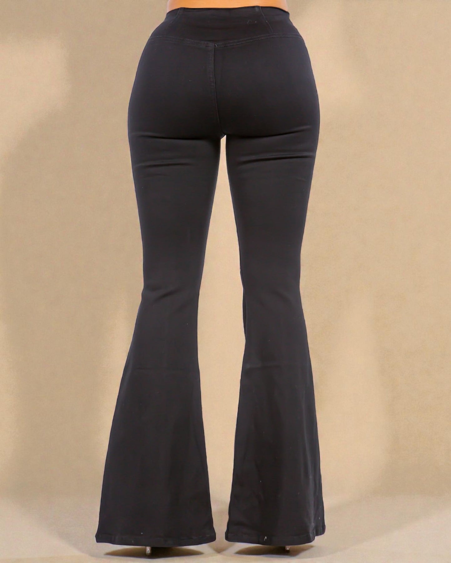 Black bell-bottom pants on a beige background