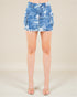 Blue camouflage skirt worn by a person on a beige background