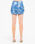 A model from the back wearing a blue and white distressed denim cargo mini skirt, paired with beige high-heeled sandals, against a plain white background.