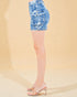 Denim shorts worn by a person on a beige background