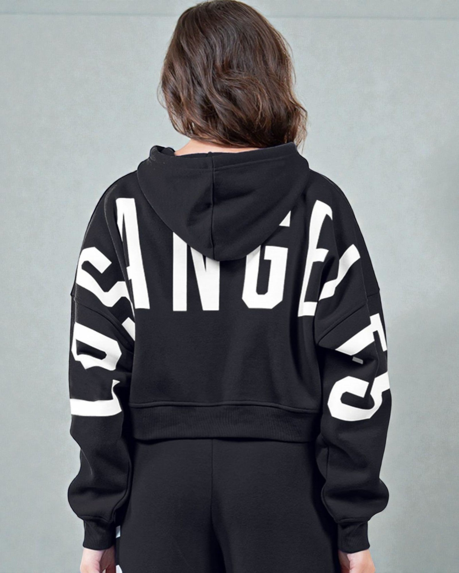 Person wearing a black hoodie with large white text on a gray background