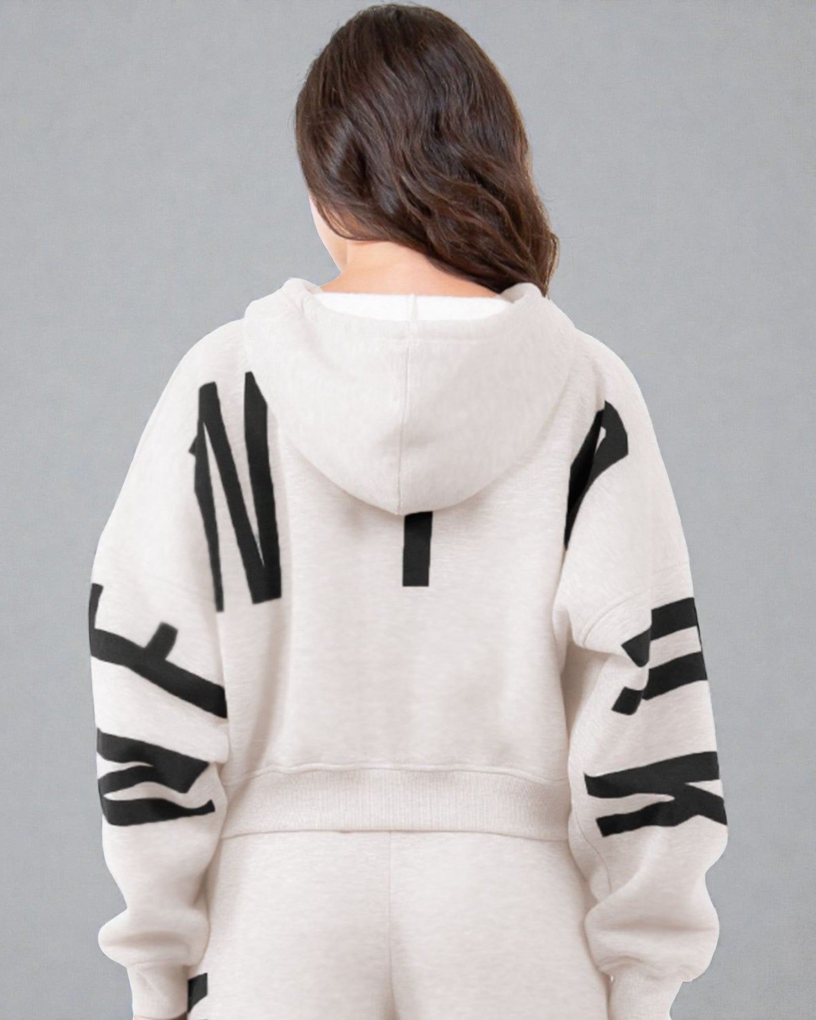 Person wearing a white hoodie with black lettering on a gray background