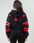 Person wearing a black hoodie with red accents on a plain background