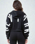 Person wearing a black hoodie with white text on the back against a light gray background